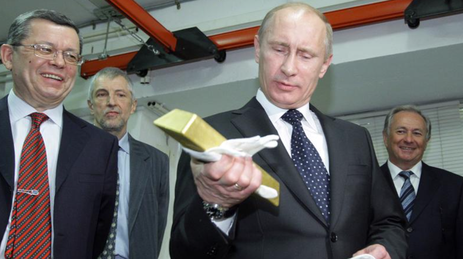 Ông Vladimir Putin cầm một thỏi vàng khi thăm Khu lưu ký Trung ương của Ngân hàng Trung ương Nga hồi tháng 1/2011 (Ảnh: AFP)